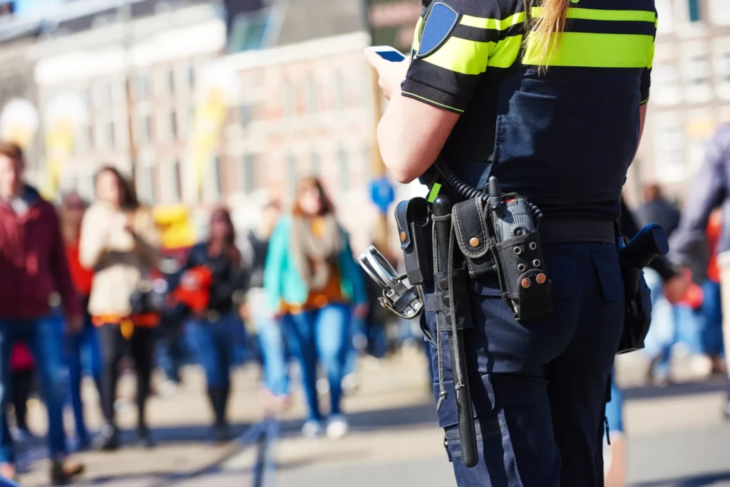 Event security officer equipped with a two-way radio while monitoring a busy public area.